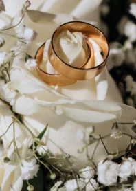 anneaux de mariage en sur la rose blanche du bouquet de mariee